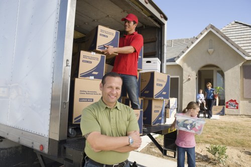 Professional movers carrying household items through a residential property